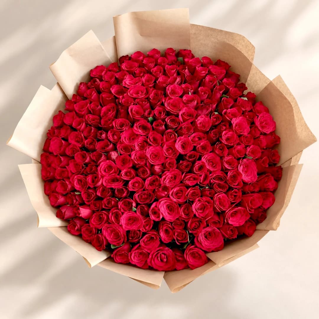 Top view of 200 red roses arranged in a grand round bouquet with premium beige wrapping.