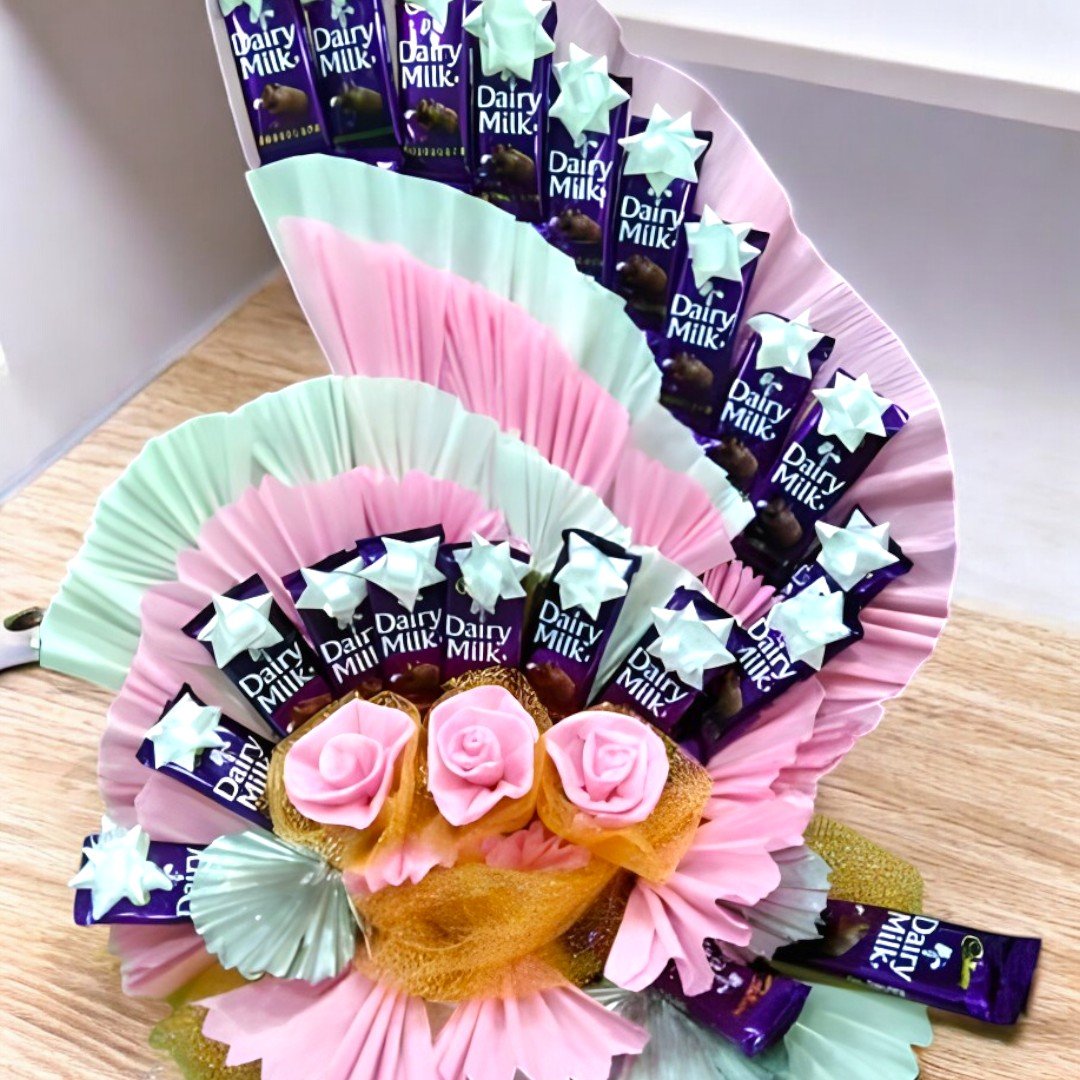 BetterGiftFlowers Dairy Milk hamper featuring 20 chocolates in a fan-shaped arrangement with pink roses and elegant decorations.