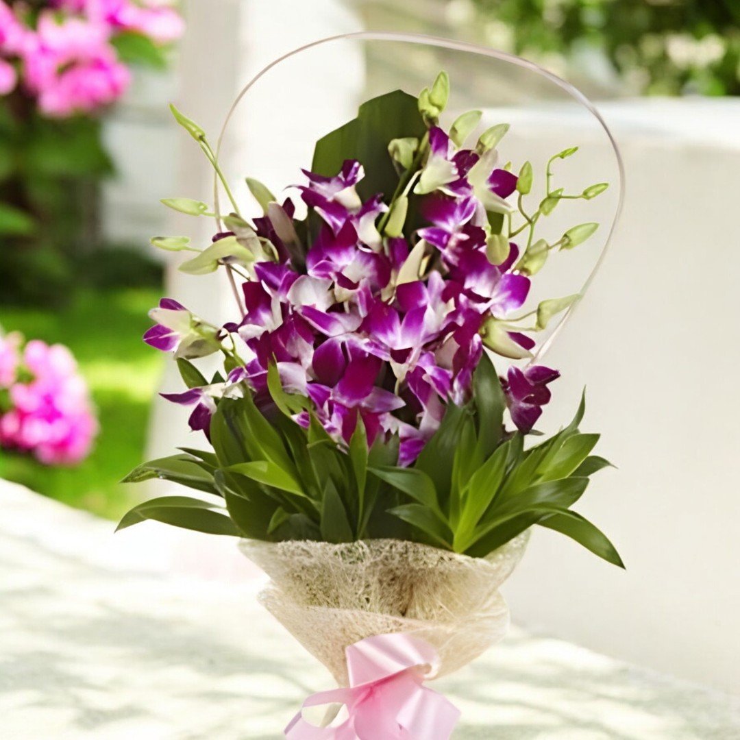 Close-up of BetterGiftFlowers elegant purple orchid bouquet against a green backdrop.