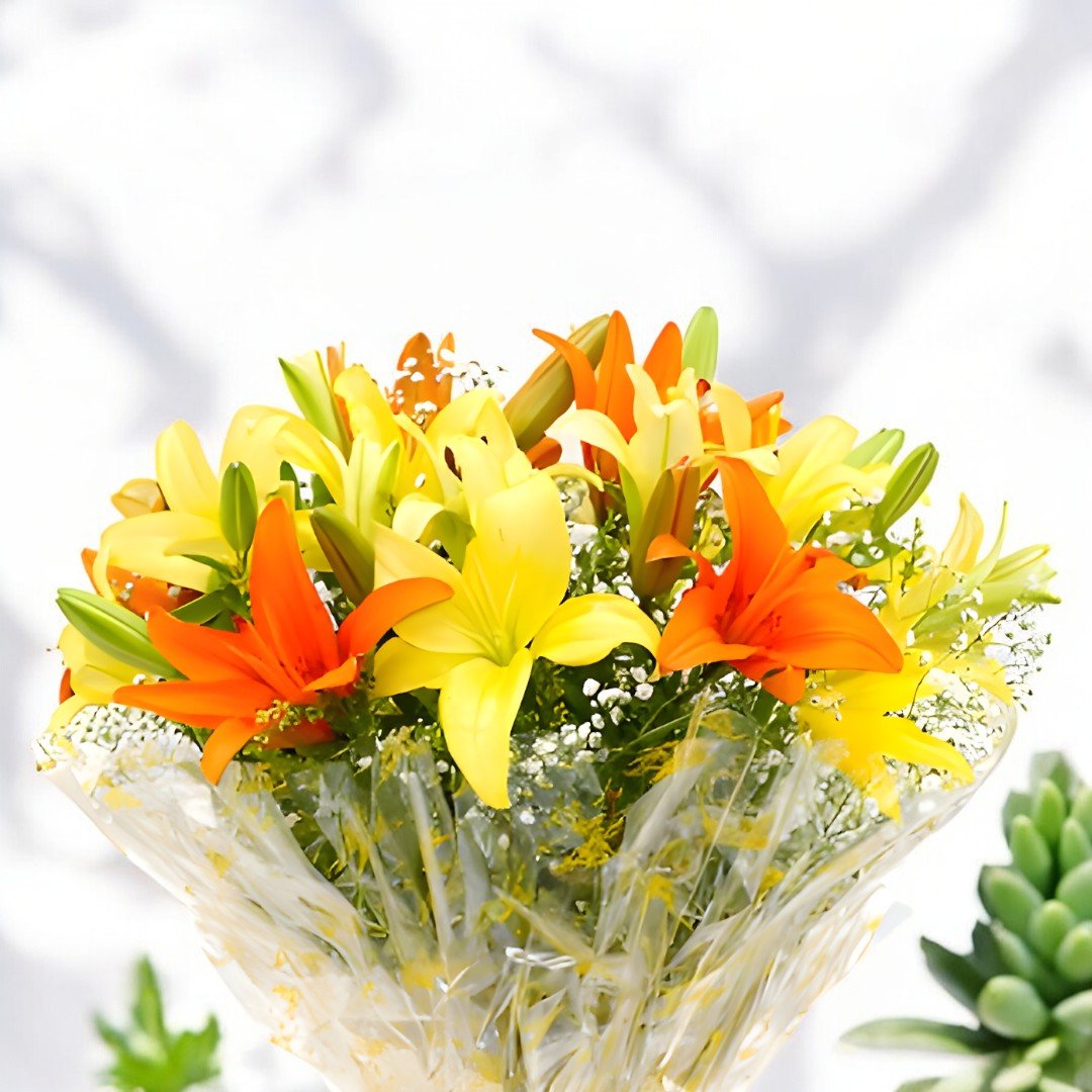 Close-up of BetterGiftFlowers Sunrise Greet Bouquet featuring orange and yellow lilies in a vibrant arrangement.