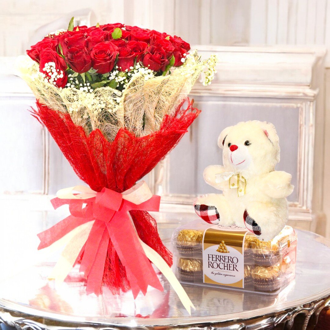 BetterGiftFlowers red rose bouquet, Ferrero Rocher chocolates, and a plush teddy bear arranged on a table