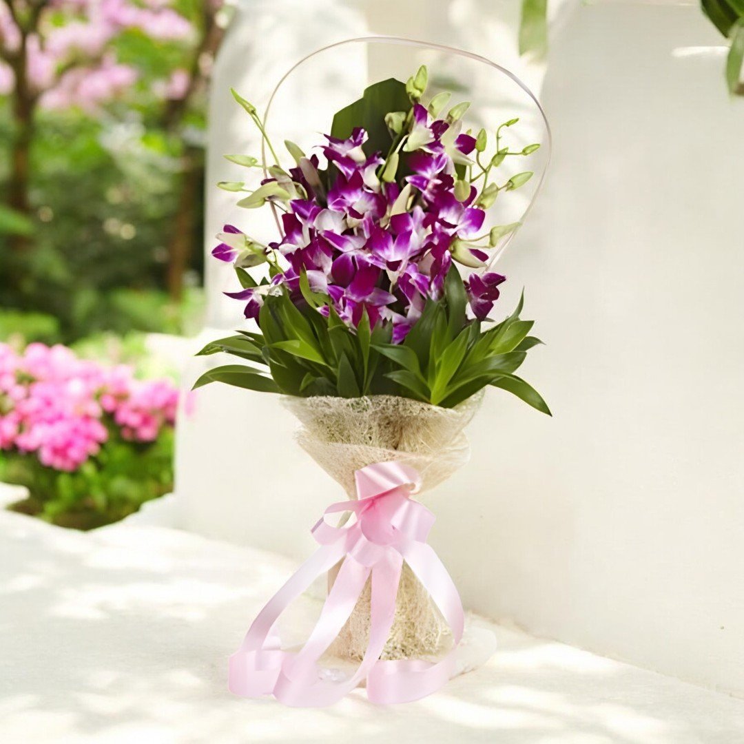 BetterGiftFlowers vibrant orchid bouquet placed outdoors with a pink ribbon, perfect for gifting.