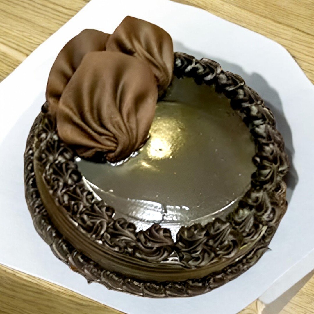 Top view of a decadent chocolate truffle cake by BetterGiftFlowers, decorated with smooth chocolate cream.