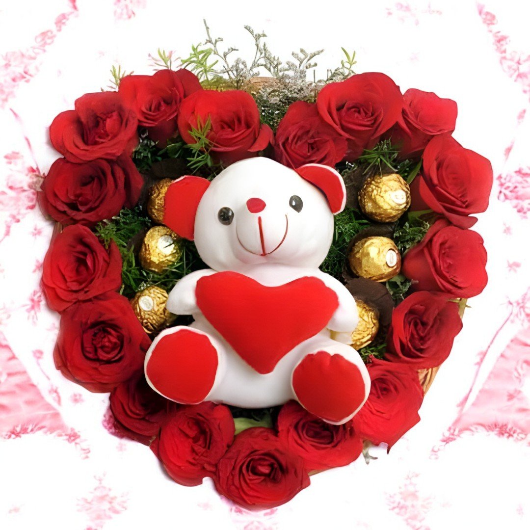 Heart-shaped arrangement of red roses with Ferrero Rocher chocolates and teddy holding a heart from Better Gift Flowers.