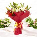 Lovely Lily bouquet with white and orange lilies, beautifully wrapped in red paper by BetterGiftFlowers