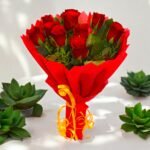 Ravishing Red rose bouquet by BetterGiftFlowers wrapped in red paper with yellow ribbon, perfect for gifting.