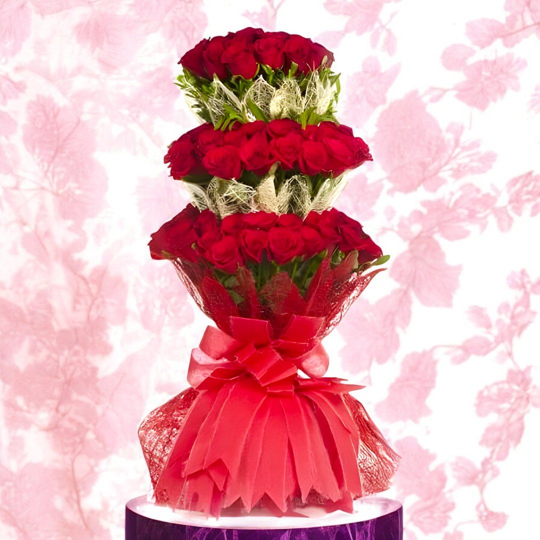 Tower Of Roses 3-tier arrangement of 100 red roses by BetterGiftFlowers, elegantly wrapped in red decorative paper.