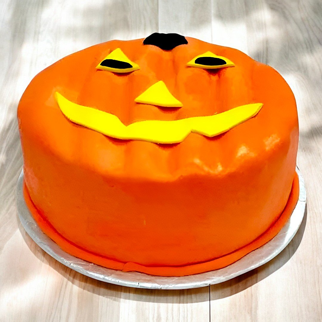 BetterGiftFlowers Halloween cake shaped like a Jack-o'-lantern with orange fondant and a smiling face.