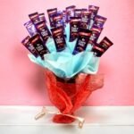 A bouquet of 20 Dairy Milk chocolates wrapped with red and blue decorative paper by BetterGiftFlowers.