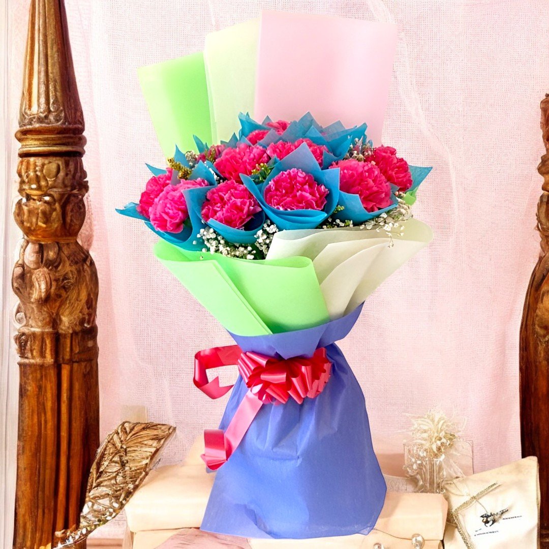 A vibrant bouquet of 12 pink carnations wrapped in pastel paper by Better Gift Flowers