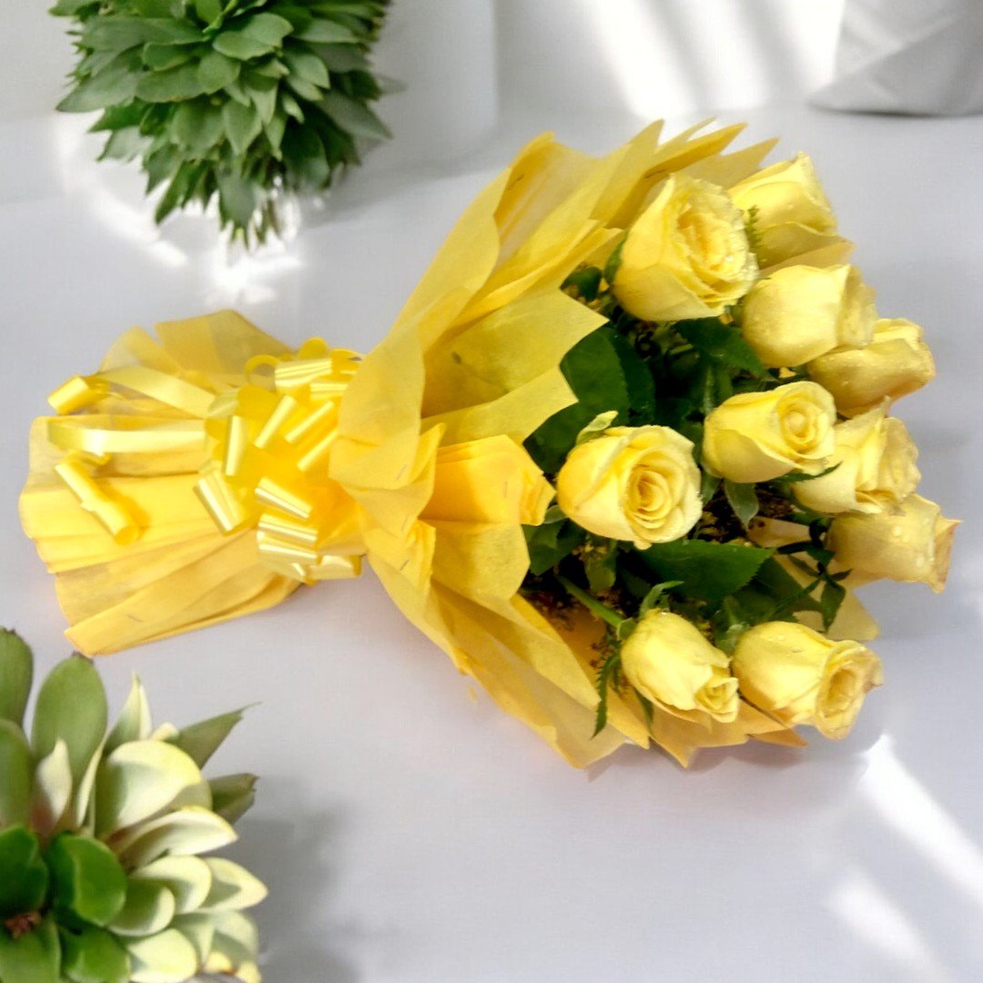 A bouquet of 10 yellow roses wrapped in yellow paper from BetterGiftFlowers.