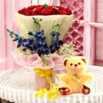 BetterGiftFlowers Elite Class bouquet featuring 20 red roses, 3 blue orchids, and a cute 6-inch teddy bear for gifting.