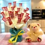 BetterGiftFlowers KitKat Gift Hamper with 20 KitKat chocolates and a teddy bear in a blue vase with yellow ribbon.