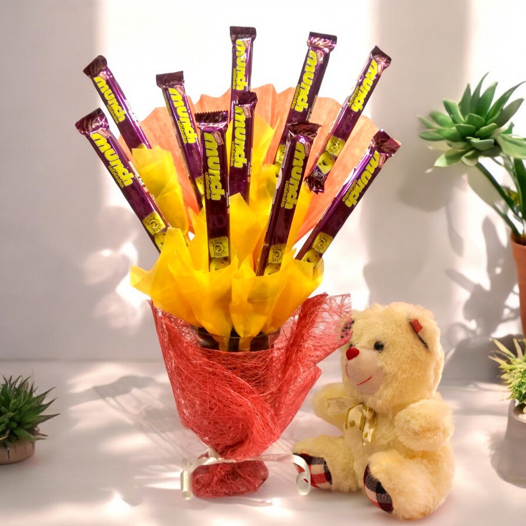 BetterGiftFlowers Munch Chocolates N Teddy Hamper with 10 Munch chocolate bars and a soft 6-inch teddy arranged in vibrant red and yellow wrapping