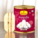 Haldiram's Rasgulla tin with Rakhi set by BetterGiftFlowers