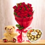 Love In The Air combo featuring a bouquet of red roses, Ferrero Rocher chocolates, and a teddy bear by BetterGiftFlowers.