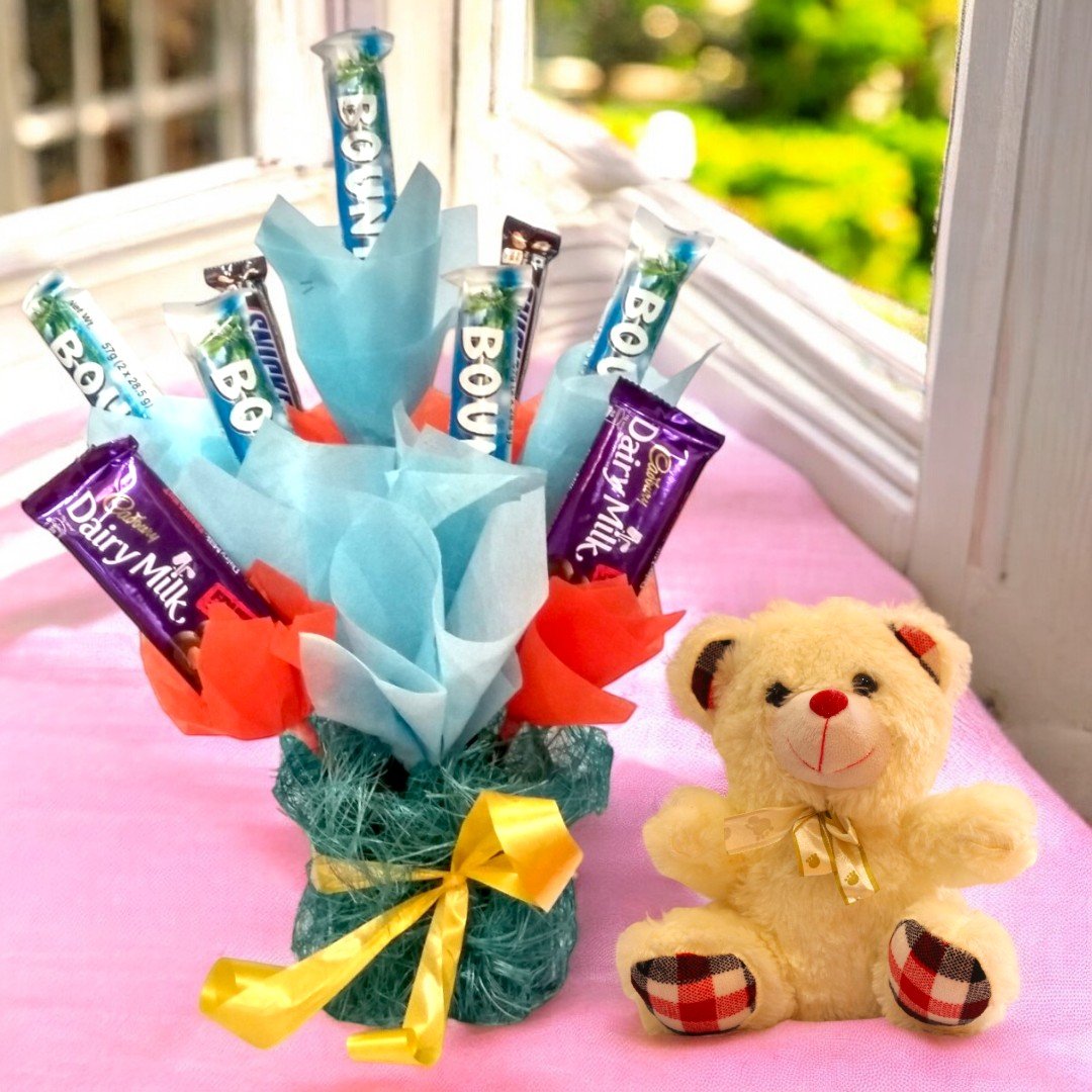 Mix Chocolate Hamper and Teddy Bear by BetterGiftFlowers with Dairy Milk, Bounty, and Snickers arranged in a colorful bouquet.