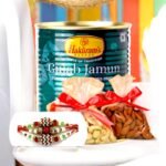 BetterGiftFlowers Sensational Rakhi Delight with 1 Kg Haldiram's Gulab Jamun, almonds, cashews, and 3 designer rakhis placed on a table