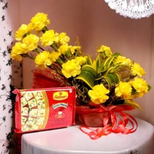 Fresh yellow carnations and Haldiram's Soan Papdi beautifully arranged by BetterGiftFlowers.