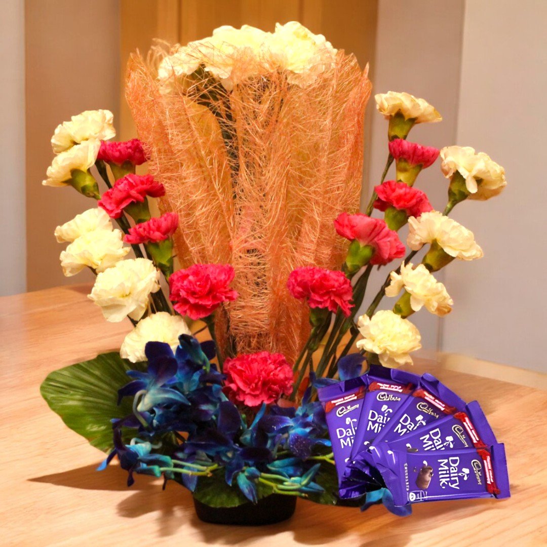 BetterGiftFlowers Mix Flowers and Chocolates arrangement with red, cream, and blue flowers with Dairy Milk chocolates.