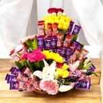 BetterGiftFlowers chocolate and flower basket with KitKat, Dairy Milk chocolates, and fresh yellow and pink flowers in a stunning arrangement.